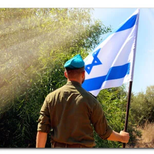 תמונת זכוכית המציגה חייל צה"ל מחזיק דגל ישראל על רקע שמיים מעוננים חלקית, עם כיתוב בעברית.