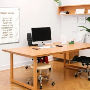 תמונת זכוכית יוקרתית עם ברכת העסק בעברית, טקסט בגוון חום בהיר על רקע פרחוני לבן-זהב, עם מחברים מוזהבים בקצוות.